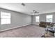 Upstairs living room featuring two windows, ceiling fan, and brown sectional sofa at 8816 Mugnai St, Riverview, FL 33578