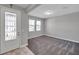 Open living room with gray carpet, two large windows, and white trim, door, and baseboards at 8816 Mugnai St, Riverview, FL 33578