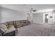 Spacious living room features plush carpeting, a ceiling fan, and a comfortable sectional sofa at 8816 Mugnai St, Riverview, FL 33578