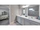 Bright main bathroom boasts a double vanity with white cabinets and a view into the main bedroom at 8816 Mugnai St, Riverview, FL 33578