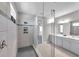 Large glass shower with gray tiling, inset shelf, and double vanity sink in the main bathroom at 8816 Mugnai St, Riverview, FL 33578