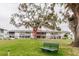 Backyard view of condo units and a green bench under a mossy tree at 105 47Th Avenue W Dr # 374, Bradenton, FL 34207