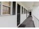 Exterior view of condo building hallway with neutral walls and black shutters at 105 47Th Avenue W Dr # 374, Bradenton, FL 34207