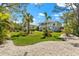 Expansive lawn with a quaint home showcasing a balcony, complemented by verdant landscaping and a serene ambiance at 1051 Point Seaside, Crystal Beach, FL 34681