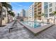 Inviting community pool with ample lounge seating, palm trees and a nearby shaded bar area at 1238 E Kennedy Blvd # 704, Tampa, FL 33602