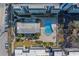 Aerial view showcasing the community pool with palm trees and surrounding condos; with a lush, tropical setting and modern amenities at 131 Bluff View Dr # 208, Belleair Bluffs, FL 33770