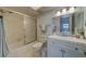 Bright bathroom featuring a shower with glass door, white tile, and updated vanity at 131 Bluff View Dr # 208, Belleair Bluffs, FL 33770