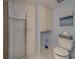 Bright bathroom featuring a shower, built-in storage, toilet with fun Beach Bum decor and a blue beach-themed art piece at 131 Bluff View Dr # 208, Belleair Bluffs, FL 33770