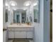Bright bathroom with a large mirror, white vanity, and soft lighting at 131 Bluff View Dr # 208, Belleair Bluffs, FL 33770