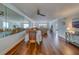 Open-concept dining area with hardwood floors, ceiling fan and views into the living room at 131 Bluff View Dr # 208, Belleair Bluffs, FL 33770