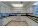 Well-lit kitchen features white cabinets, modern appliances, and sleek countertops at 131 Bluff View Dr # 208, Belleair Bluffs, FL 33770