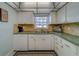 Well-lit kitchen with stainless sink, ample counter space and bright white cabinets at 131 Bluff View Dr # 208, Belleair Bluffs, FL 33770