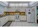 Bright kitchen features white appliances, tile floor, and a classic design at 131 Bluff View Dr # 208, Belleair Bluffs, FL 33770