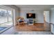 Bright living room featuring wood floors, balcony, and a tv at 131 Bluff View Dr # 208, Belleair Bluffs, FL 33770