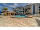 Exterior view of the community pool and poolhouse, lined with tropical palm trees and plenty of room for recreation at 131 Bluff View Dr # 208, Belleair Bluffs, FL 33770