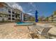 Community pool area, complete with a cozy seating arrangement, blue umbrellas and an overview of the surrounding property at 131 Bluff View Dr # 208, Belleair Bluffs, FL 33770