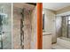 Updated bathroom featuring a glass-doored shower with decorative tile and fixtures and view to the vanity at 13112 Groveland St, Spring Hill, FL 34609