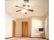 Bedroom with ceiling fan, neutral paint, and two wood-paneled doors at 13112 Groveland St, Spring Hill, FL 34609