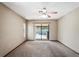Bright bedroom with carpet flooring, a ceiling fan, and sliding glass doors leading to the screened pool area at 13112 Groveland St, Spring Hill, FL 34609