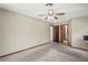 A bedroom featuring neutral walls and carpet, ceiling fan, and entryways to an ensuite and walk-in closet at 13112 Groveland St, Spring Hill, FL 34609