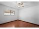 Cozy bedroom with wood floors, a ceiling fan, and natural light from a sunny window at 13112 Groveland St, Spring Hill, FL 34609