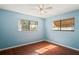 Blue bedroom with hardwood floors, ceiling fan, and windows at 13112 Groveland St, Spring Hill, FL 34609