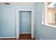 Blue bedroom with hardwood floors and open double door closet at 13112 Groveland St, Spring Hill, FL 34609