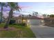 Charming single-story home featuring a well-manicured lawn, mature palm trees, and a two-car garage at 13112 Groveland St, Spring Hill, FL 34609