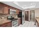 Kitchen with stainless steel appliances and dark wood cabinetry at 13112 Groveland St, Spring Hill, FL 34609