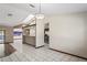 Spacious living room with white tile, open layout, and kitchen view at 13112 Groveland St, Spring Hill, FL 34609