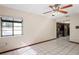 Open living room with bright tile flooring, ceiling fan and kitchen view at 13112 Groveland St, Spring Hill, FL 34609