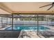 Covered patio view of pool area complete with in-ground pool, screened-in enclosure, and bench seating at 13112 Groveland St, Spring Hill, FL 34609