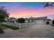 Charming home with a paver driveway, white picket fence, and well-manicured lawn at dusk at 1350 Maple Sw St, Largo, FL 33770