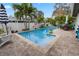 This backyard boasts a beautiful pool, patio seating, and lush landscaping at 1350 Maple Sw St, Largo, FL 33770
