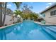 This backyard boasts a beautiful pool, patio seating, and lush landscaping at 1350 Maple Sw St, Largo, FL 33770