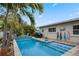 Sparkling blue pool area complete with a waterfall feature, tropical landscaping, and patio seating at 1350 Maple Sw St, Largo, FL 33770