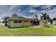 View of backyard, featuring a chain link fence, an enclosed lanai and green grass at 18236 Ackerman Ave, Port Charlotte, FL 33948