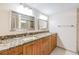 Bathroom featuring double sinks with granite countertops and beautifully-framed mirrors with overhead lighting at 19029 Us Highway 19 N # 30H, Clearwater, FL 33764