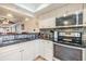 Bright kitchen with white cabinets, stainless steel appliances, granite countertops, and mosaic backsplash at 19029 Us Highway 19 N # 30H, Clearwater, FL 33764