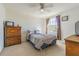 Cozy bedroom with a ceiling fan, window view, and a classic wooden dresser for ample storage at 20326 Merry Oak Ave, Tampa, FL 33647