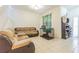 Bright living room featuring tile floors, a comfortable sofa, and a pet kennel at 20326 Merry Oak Ave, Tampa, FL 33647