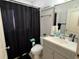 Bathroom featuring a toilet, sink and vanity, and shower with black curtain at 2218 Egret Walk Ct, New Port Richey, FL 34655