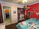 Bright bedroom with hardwood floors, colorful decor, and a glimpse into an adjacent room at 2218 Egret Walk Ct, New Port Richey, FL 34655