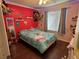 Bedroom featuring wood floors, a bright red accent wall, and a window with natural light at 2218 Egret Walk Ct, New Port Richey, FL 34655