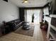 Cozy living room with tile floors, dark leather sectional, and a decorative fireplace at 2218 Egret Walk Ct, New Port Richey, FL 34655