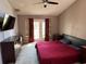 Main bedroom featuring a ceiling fan, plush carpet, and a door leading to the outdoors at 2218 Egret Walk Ct, New Port Richey, FL 34655