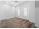 Bright bedroom with wood-look floors, ceiling fan, plantation shutters, and neutral paint at 2240 Soho Bay Ct, Tampa, FL 33606