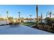 Scenic backyard featuring a stone patio with outdoor dining set, lush green lawn, and tropical landscaping at 2411 And 2407 Casey Key Rd, Nokomis, FL 34275