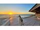 Seaside backyard featuring a statue overlooking the pool and ocean, with a beautiful sunset on the horizon at 2411 And 2407 Casey Key Rd, Nokomis, FL 34275