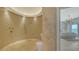 Modern bathroom boasts a luxurious tiled shower with gold accents, and a serene view of the ocean visible from the bedroom at 2411 And 2407 Casey Key Rd, Nokomis, FL 34275